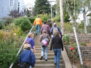 Folks walking up cement steps in a garden
